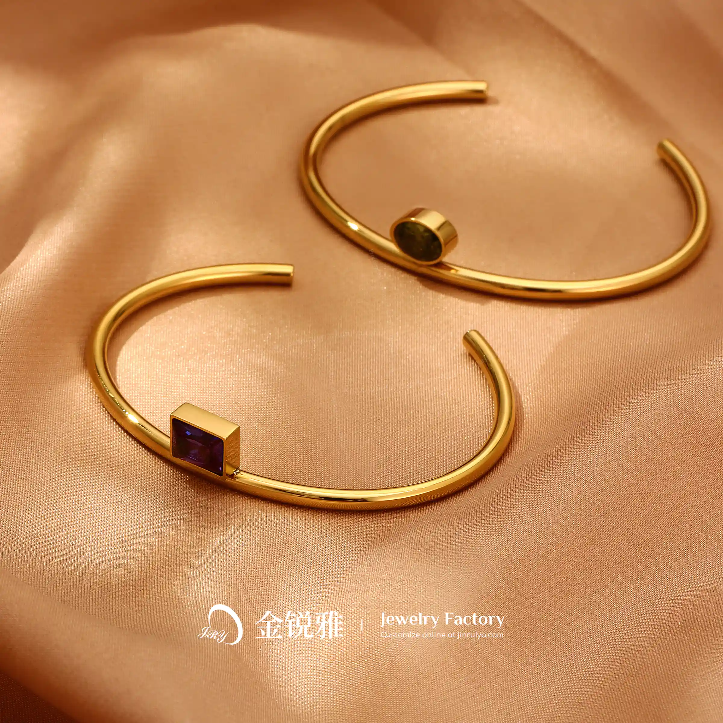 Two C-shaped open zirconia bracelets are displayed